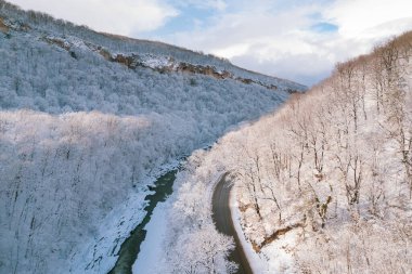 Kışın Lago-Naki Dağları 'nın uçan manzarası ve araba sürüşü. Destansı, karlı beyaz kış ve karlı orman.