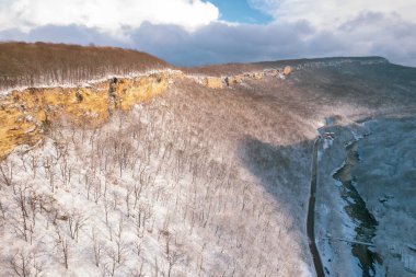 Kışın Lago-Naki Dağları 'nın uçan manzarası ve araba sürüşü. Destansı, karlı beyaz kış ve karlı orman.