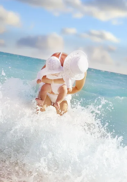 Young woman with her baby in the sea — Stock Photo, Image