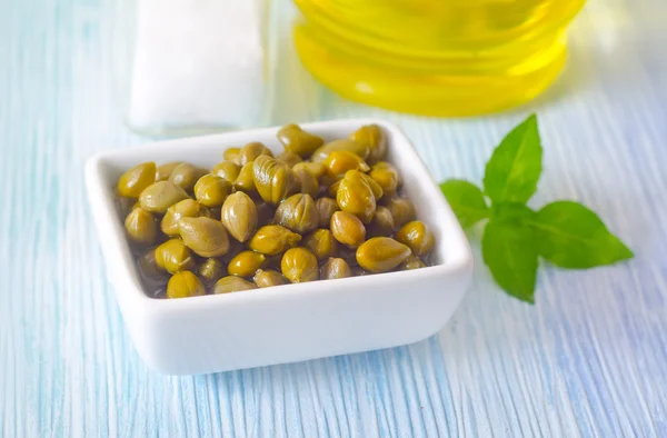 Green capers in a white plate — Stock Photo, Image