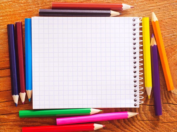 Kleurpotloden en een notitieboekje — Stockfoto