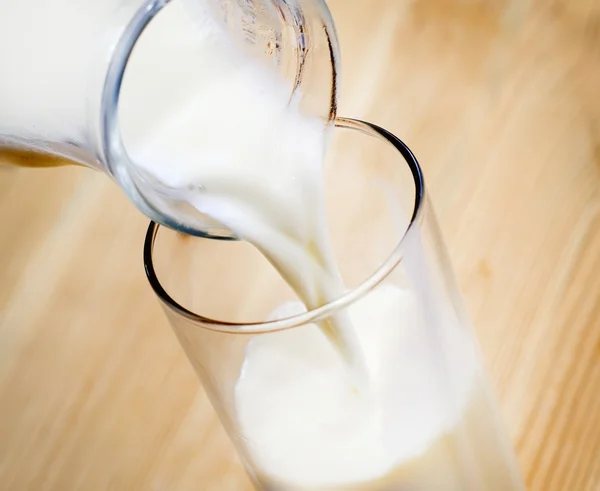 Milk into a glass — Stock Photo, Image