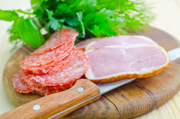 Salami och skinka på skärbräda — Stockfoto