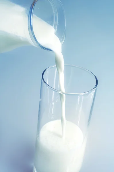 Despeje o leite em um copo — Fotografia de Stock