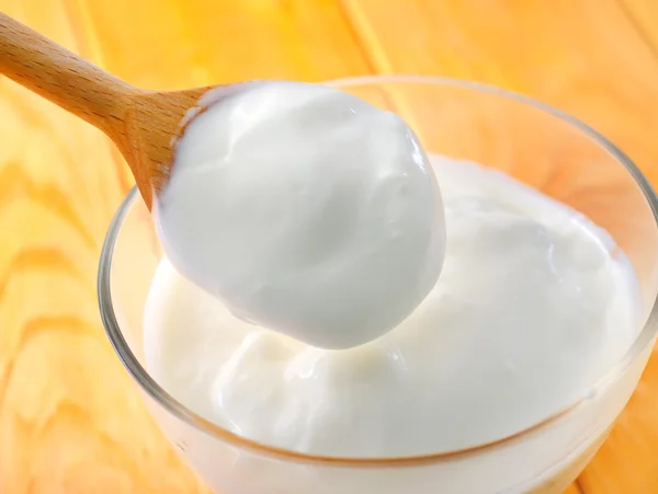 Fresh sour cream in a wooden spoon — Stock Photo, Image