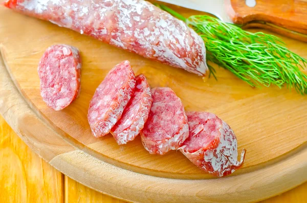 Salami on a wooden board — Stock Photo, Image