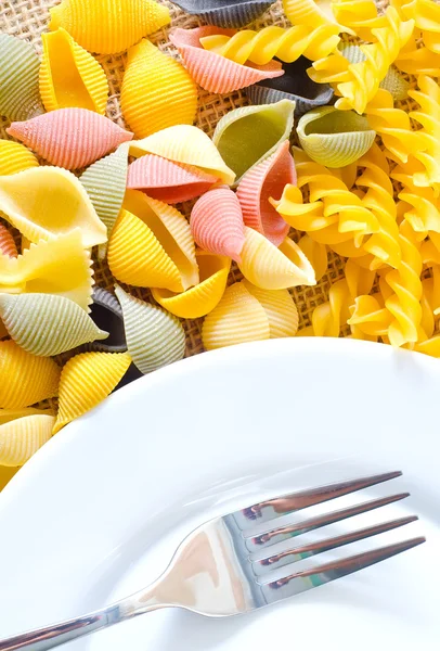 Pâtes colorées et assiette et fourchette — Photo