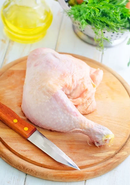 Pollo crudo e coltello sulla tavola di legno — Foto Stock