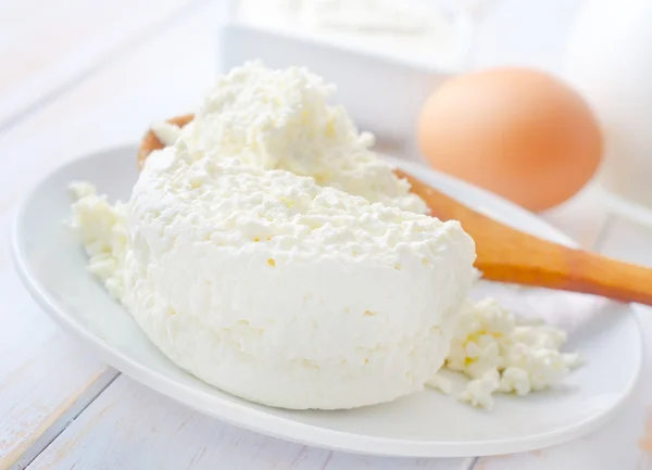 Молочные продукты, свежий коттедж в белой тарелке — стоковое фото