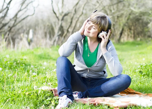 Wooman joven con auriculares Imagen de stock