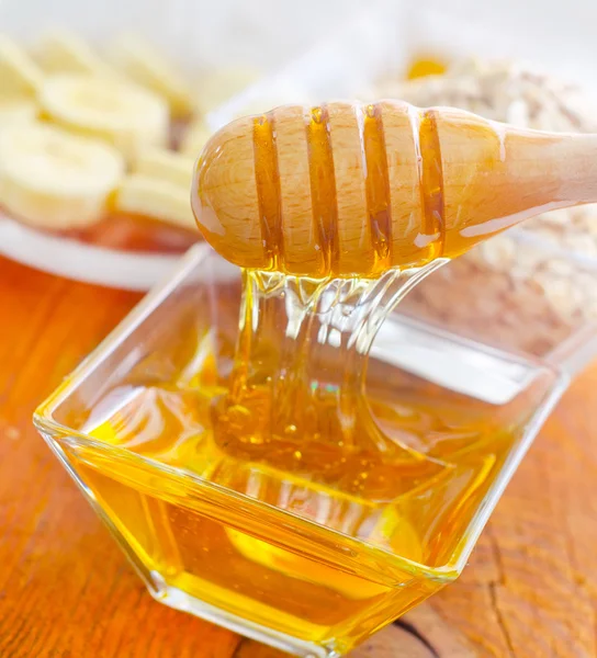 Honing in de glazen kom op houten tafel — Stockfoto