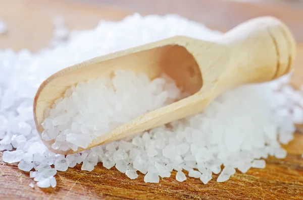 Соль в деревянной лопатке — стоковое фото