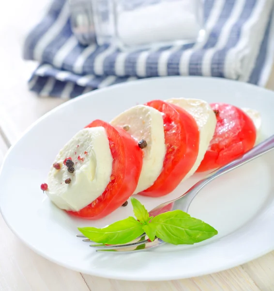 Caprese med tomat och basilika på en tallrik — Stockfoto