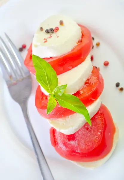 Caprese s rajčaty a bazalkou na talíři — Stock fotografie