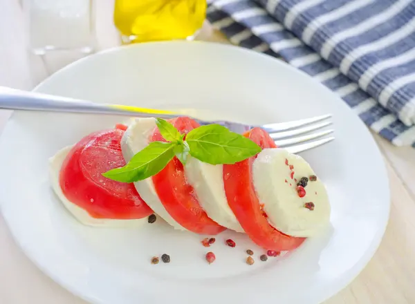Caprese s rajčaty a bazalkou na talíři — Stock fotografie