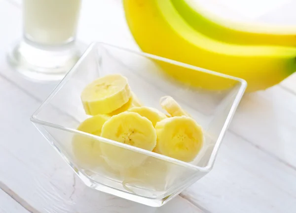 Verse bananen in de glazen kom, bananen en melk — Stockfoto