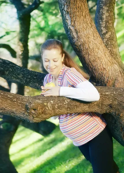 Mulher grávida no parque posando perto de uma árvore — Fotografia de Stock
