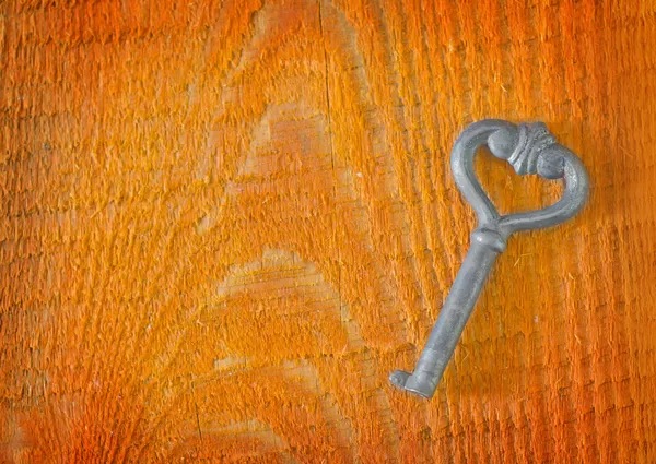 Key on wooden background — Stock Photo, Image