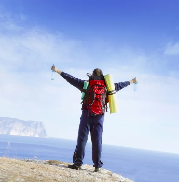 Man with backpack standing with raised hands — Stock Photo, Image