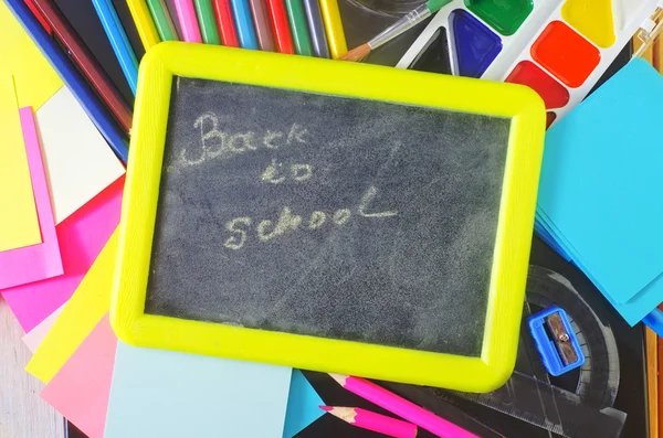 Blackboard and school supplies — Stock Photo, Image