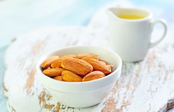 Aceite esencial de almendra y almendra en tazón — Foto de Stock