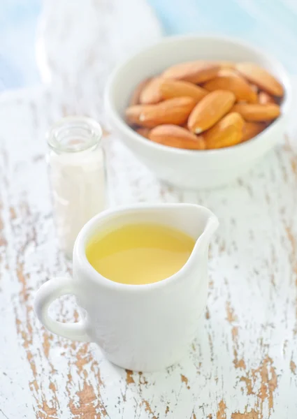 Almond essential oil and almond in bowl — Stock Photo, Image