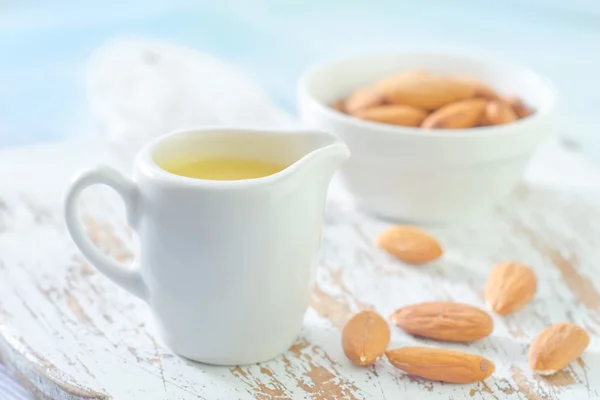 Almond essential oil and almond in bowl — Stock Photo, Image