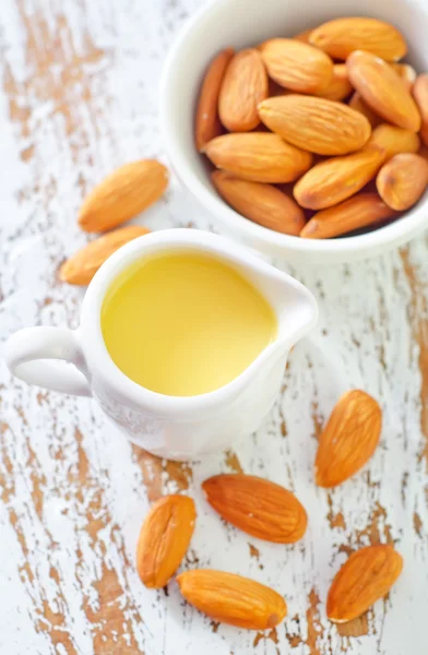 Almond essential oil and almond in bowl — Stock Photo, Image