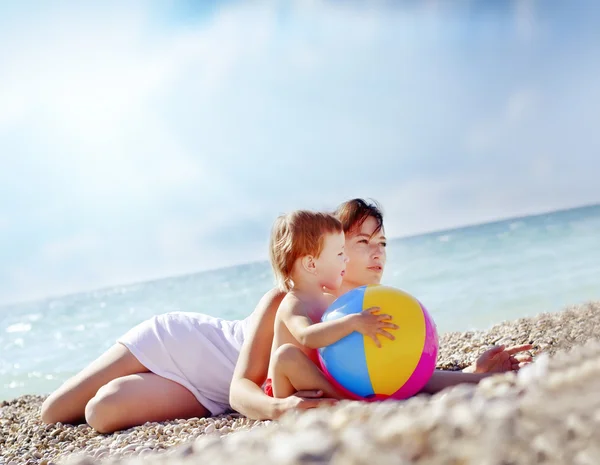 Kobieta z jej baby na plaży — Zdjęcie stockowe