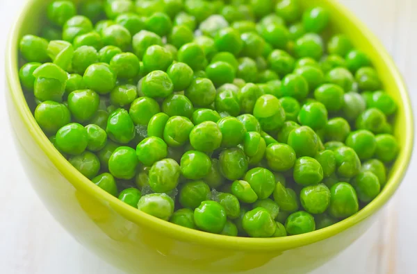 Guisantes verdes frescos en el tazón verde — Foto de Stock