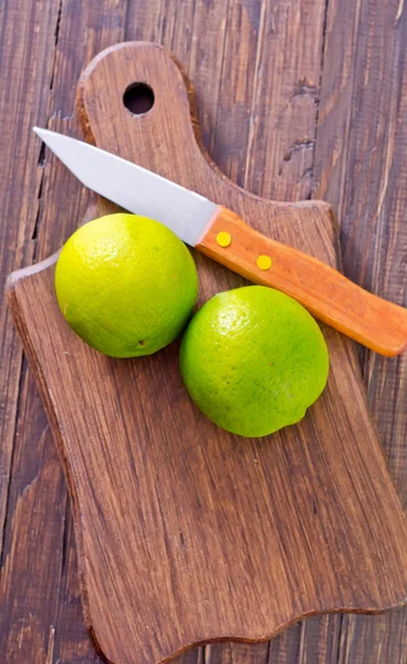 Limas en una tabla de madera —  Fotos de Stock