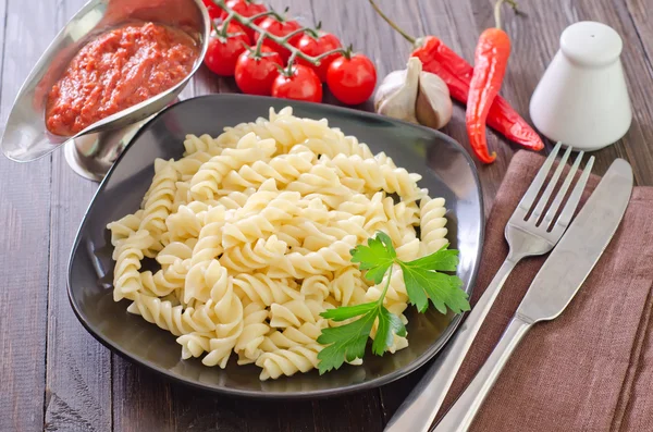 Pasta on black plate — Stock Photo, Image