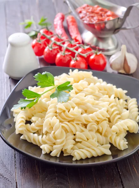 Pasta on black plate — Stock Photo, Image