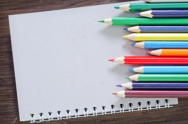 Цветные карандаши и примечание — стоковое фото