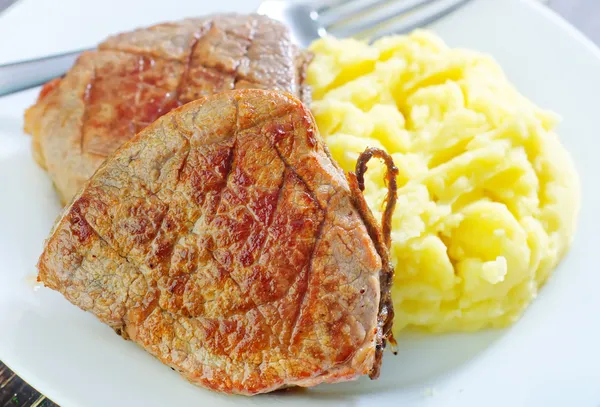 Пюре с картошкой и жареным мясом — стоковое фото