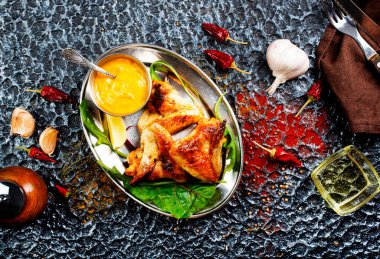 Beyaz bir tabakta ızgara tavuk kanadı.