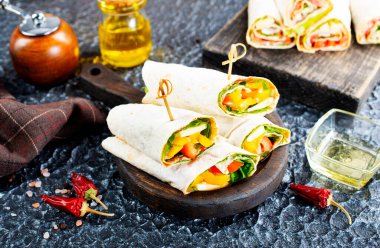 Sağlıklı tortilla, ahşap kesim tahtasından görülür. Tavuk ve sebzeli tortilla.