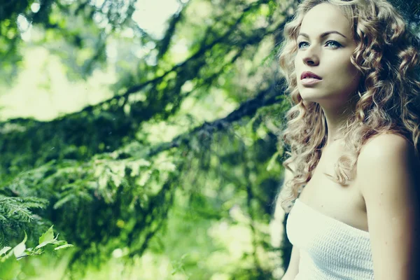 Fashion portrait of young beautiful blond woman in forest — Stock Photo, Image
