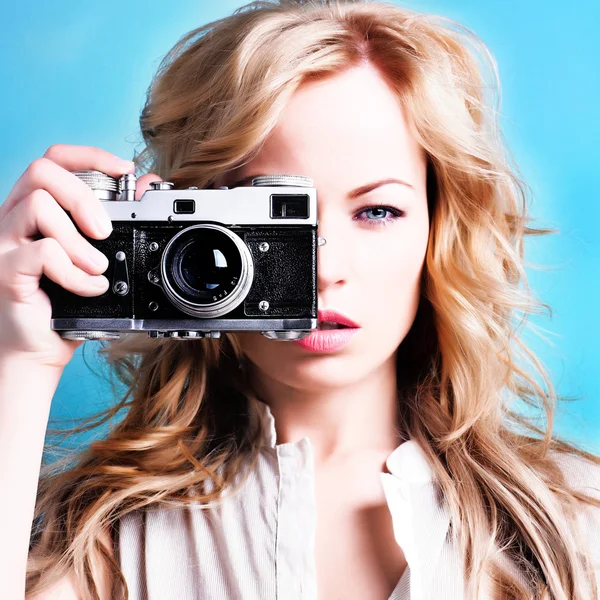 Retro kamera tutan güzel sarışın fotoğrafçı kadın