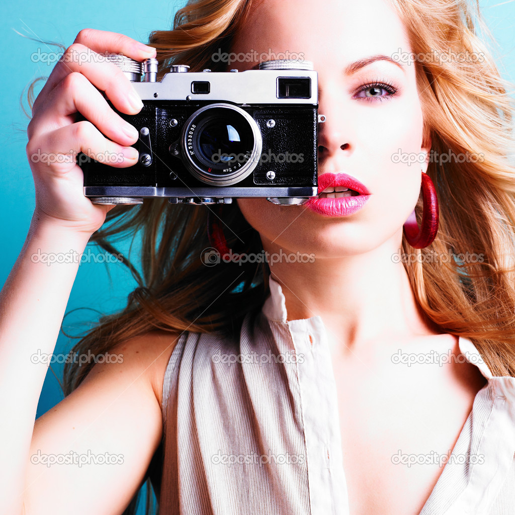 Beautiful blond photographer woman holding retro camera