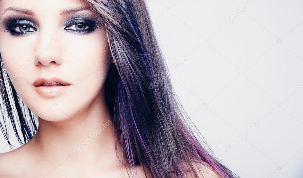 Portrait of beautiful young woman with long colored brown hair and bright make-up