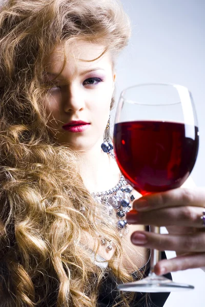 Hermosa mujer con vino tinto de cristal — Foto de Stock