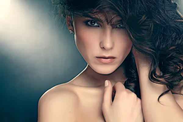 mode foto van sensuele brunette vrouw met glanzende krullend haar