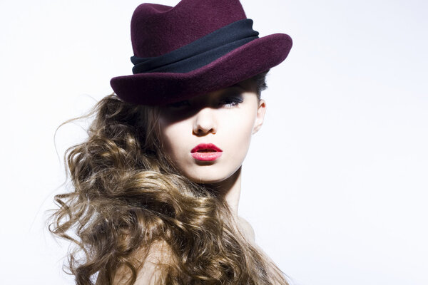 Beautiful young model in hat on the white background. Contrast photo
