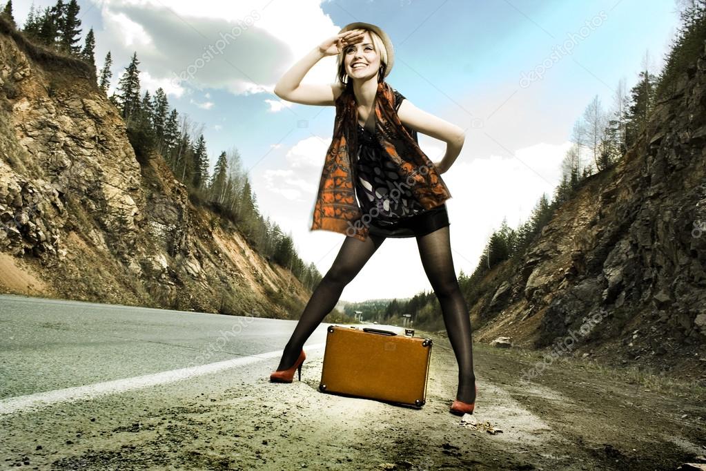 girl hitchhiking with suitcase