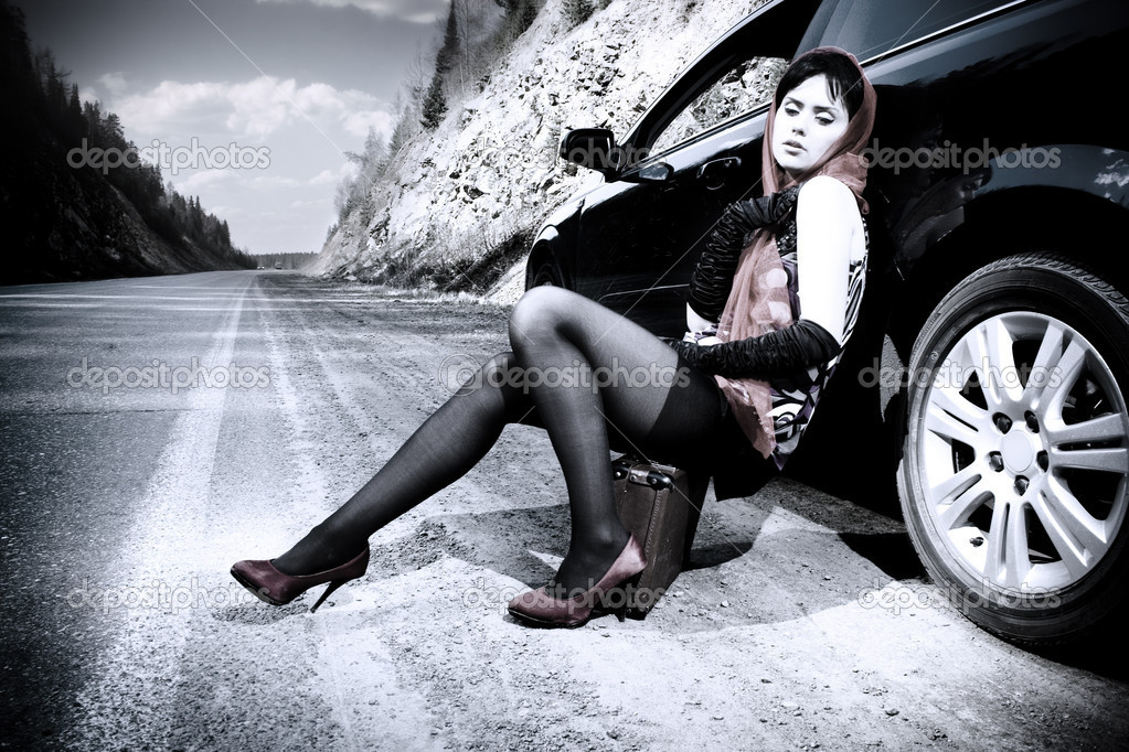 attractive girl with the suitcase near the car