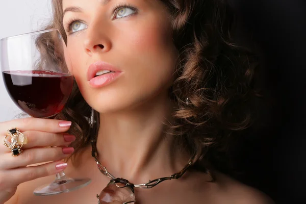 Hermosa mujer con vino tinto de cristal — Foto de Stock
