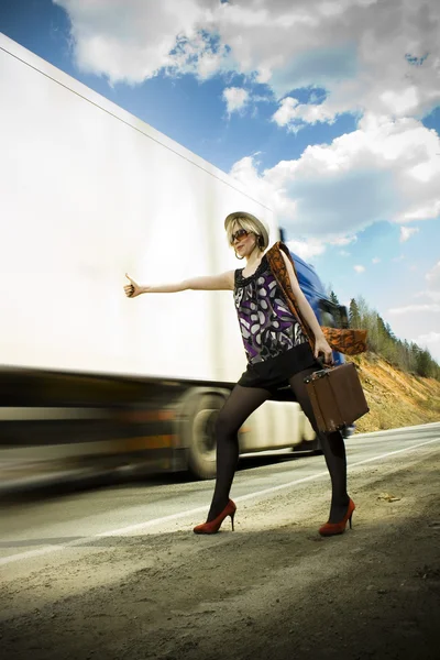 Girl hitchhiking with suitcase — Stock Photo, Image