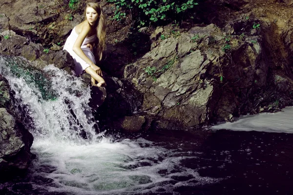 Hermosa chica en piedras — Foto de Stock