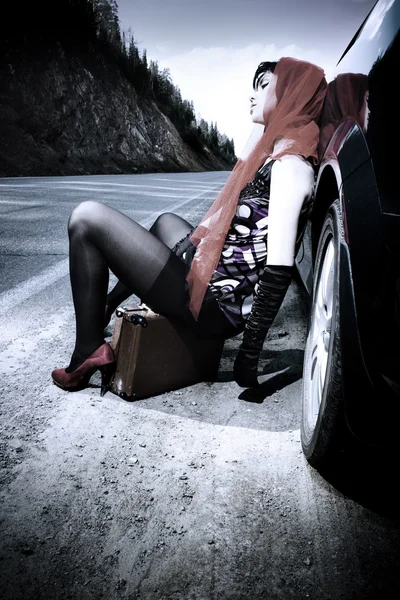 Привлекательная девушка с чемоданом рядом с машиной — стоковое фото
